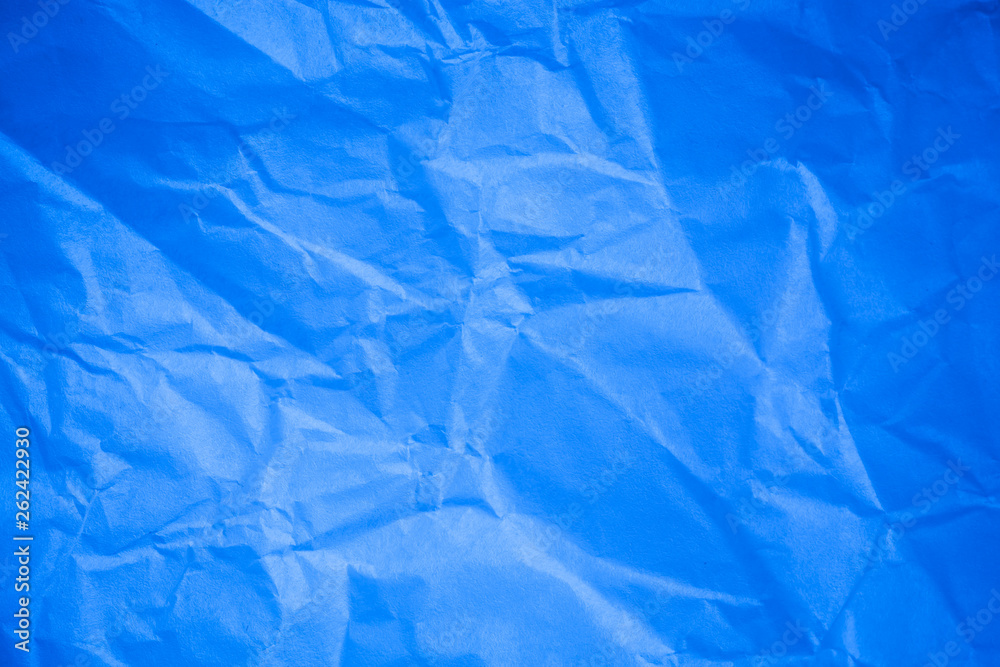 Obraz premium Crumpled blue paper background.