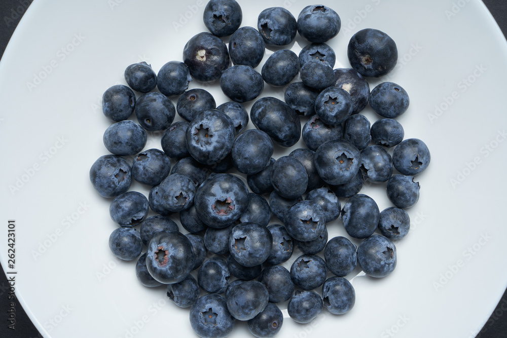 Blueberries on a white disc with black background Blueberries on a white disc with black background