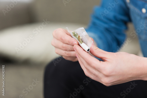 teenage girl rolling a joint
