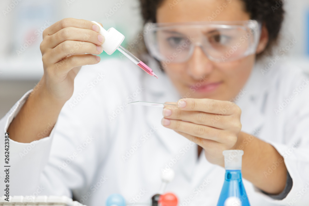 female scientist using pipettes in lab female scientist using pipettes in lab