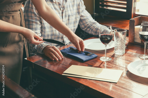 Waiter serving guest in restaurant