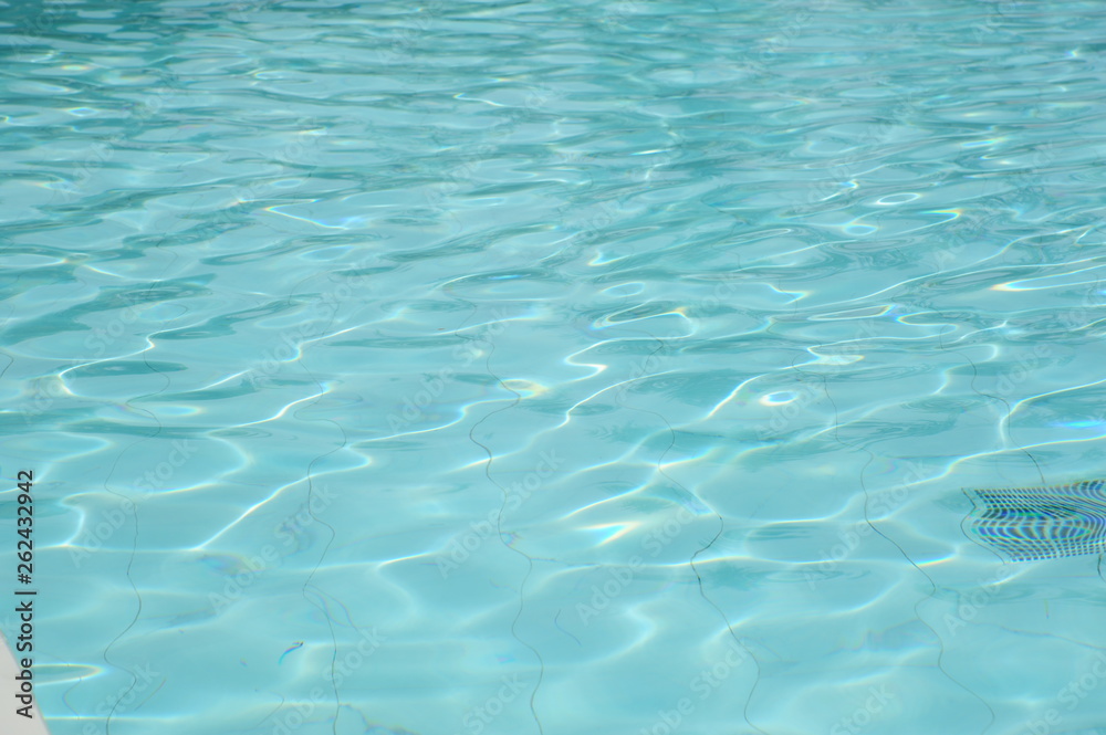 ippled Water abstract background, close up. Outdoor swimming pool in sunlight. Beautiful clear blue water background