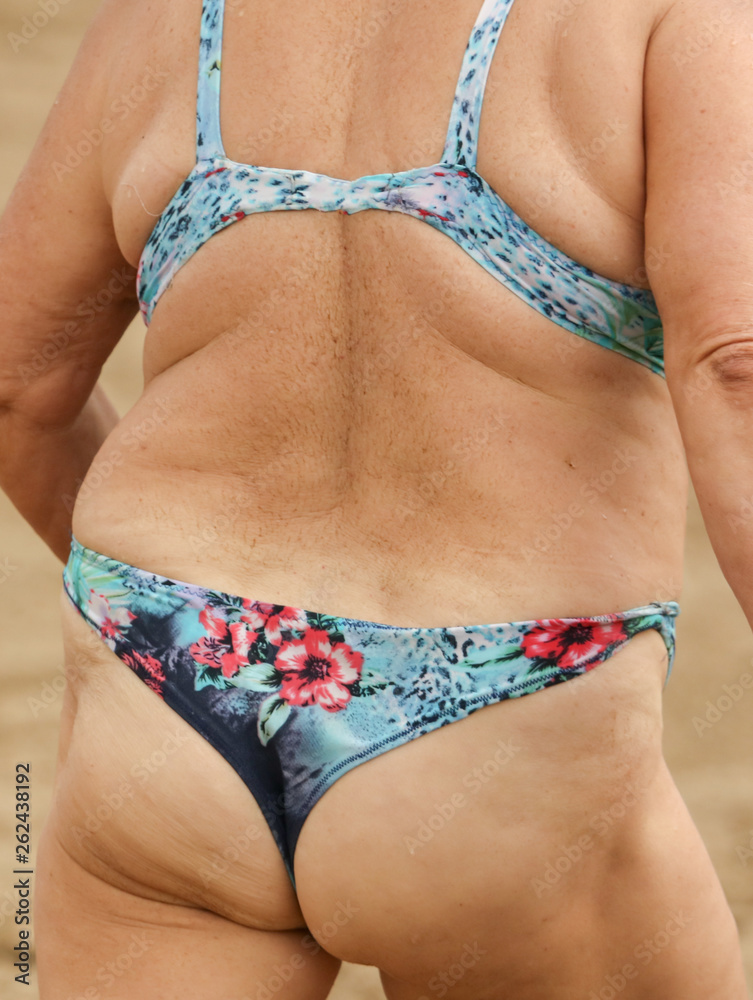 Booty old woman in a swimsuit on the beach Stock Photo