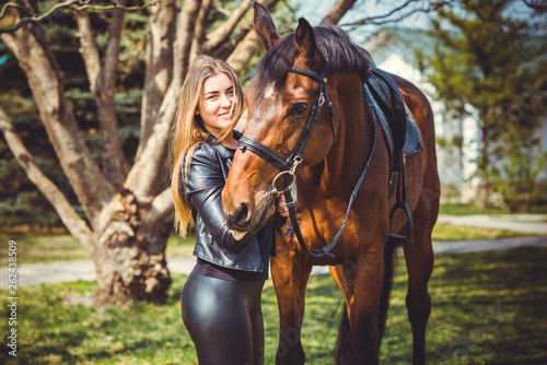 Rider elegant woman talking to her horse. Portrait of horse pure breed with woman. Equestrian horse with rider playpen for horses background 
