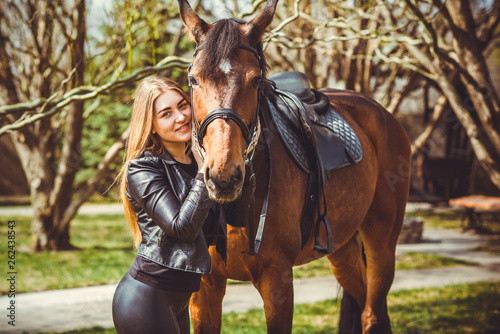 Rider elegant woman talking to her horse. Portrait of horse pure breed with woman. Equestrian horse with rider playpen for horses background 