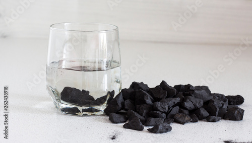 Russian shungite stones on a white background used in alternative medicine for water purification and recharge due to high carbon content and metaphysical properties