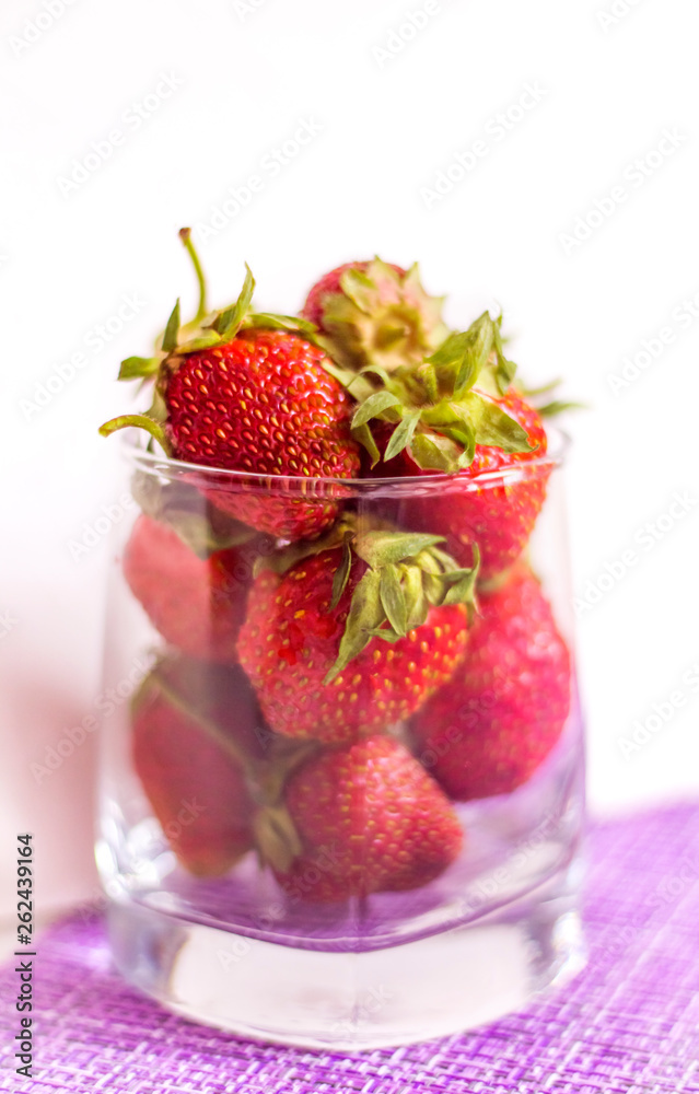glass of red ripe strawberries on a light background glass of red ripe strawberries on a light background