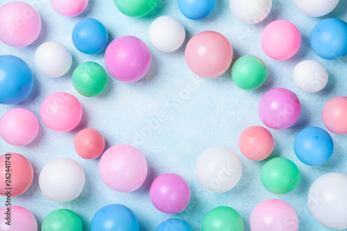 Colorful balloons on blue table top view. Birthday or party background. Flat lay style. © juliasudnitskaya
