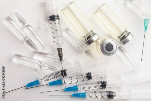 Subcutaneous syringe. Syringes with blue needles. Medical Injectors. Medical glass injection bottle. Ampoules with injections.