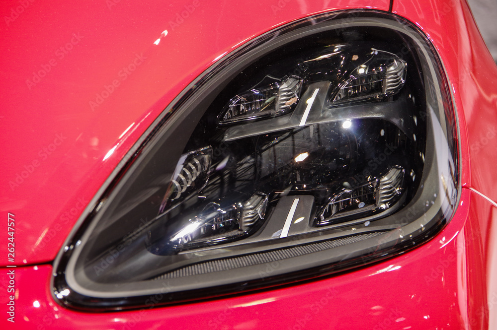 Red modern sports car dark smoked black LED headlight detail