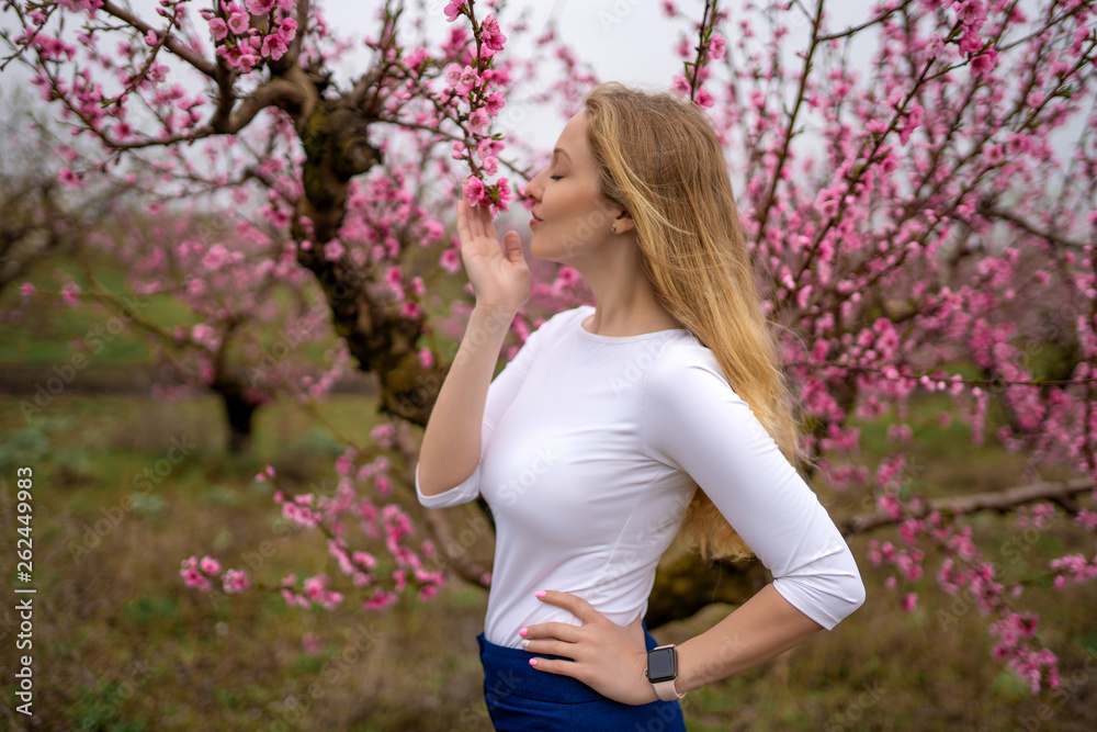 Beautiful blonde girl in spring peach blossom garden close up portrait Beautiful blonde girl in spring peach blossom garden close up portrait