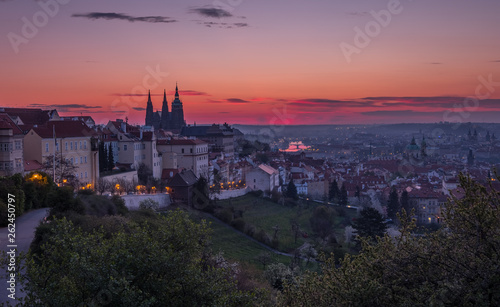 A beautiful spring view of Prague at sunrise from Petrin hill. Prague Castle and St. Vitus Cathedral on the left and a golden rising sun in the background