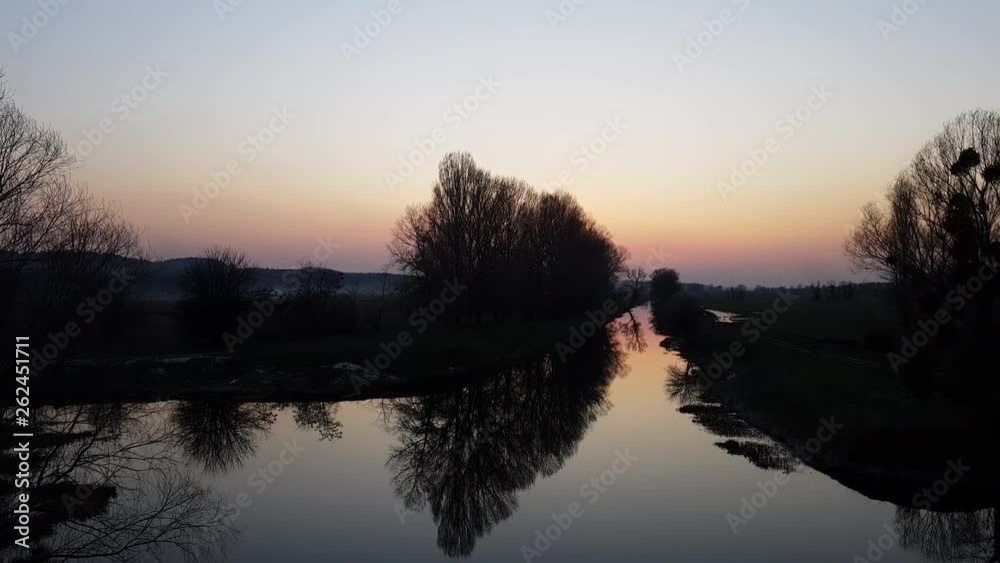 Beautiful early spring river landscape. Dried cane, near water, trees and pine forest along the river, evening, sunset, twilight. Panoramic 4k video Beautiful early spring river landscape. Dried cane, near water, trees and pine forest along the river, evening, sunset, twilight. Panoramic 4k video