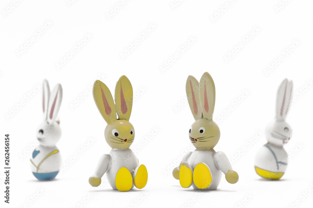 Obraz premium Two toy Easter bunnies sitting side by side with their father and mother turning their backs on each other in the background. Quarrel, divorce. Children suffer.