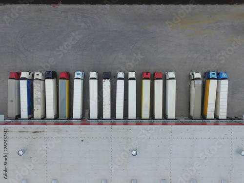 Aerial view of goods warehouse. Logistics center in industrial city zone from above. Aerial view of trucks loading at logistic center