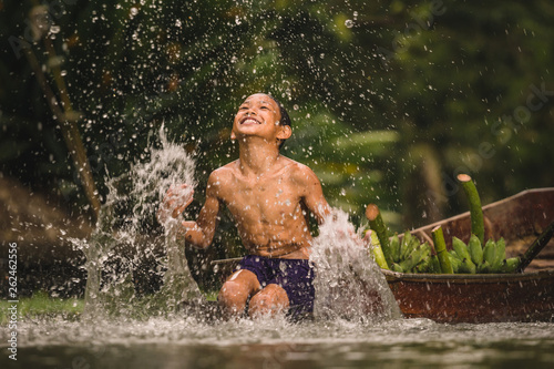 Boy swimming in the cannal near the Damnoen Saduak Floating Market