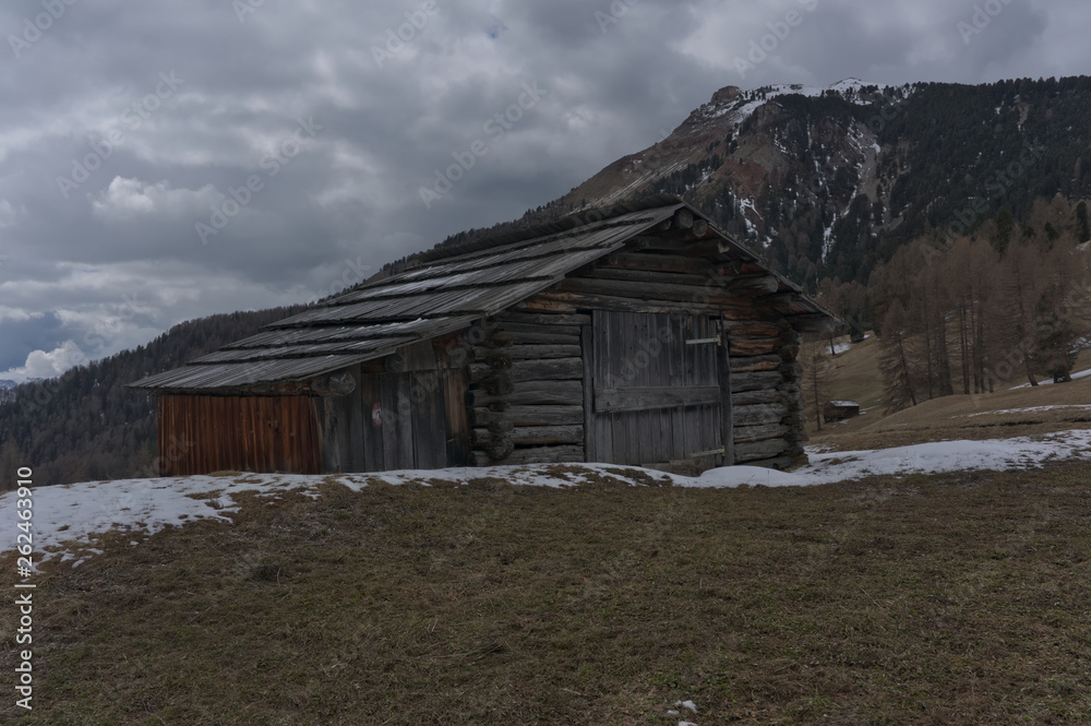 Wooden chalet with snow and ice with a view onto Langkofel Dolomites mountain peak on the Seiser Alm, South Tyrol, Italy in winter. Wooden chalet with snow and ice with a view onto Langkofel Dolomites mountain peak on the Seiser Alm, South Tyrol, Italy in winter.