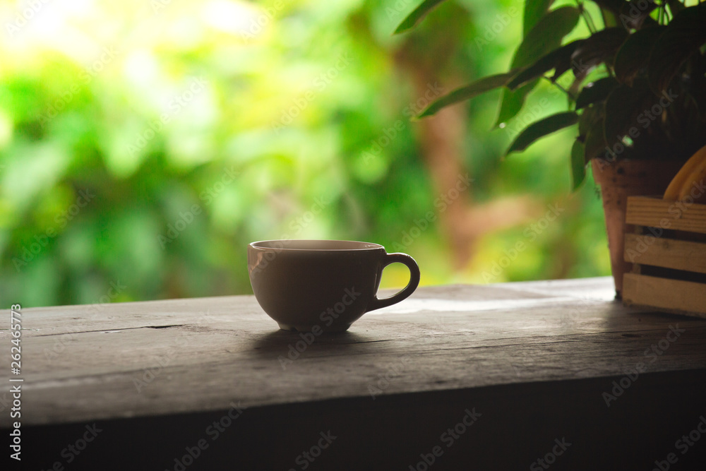 A wooden table in balcony garden with a cup of coffee. Beverage design on relaxation space