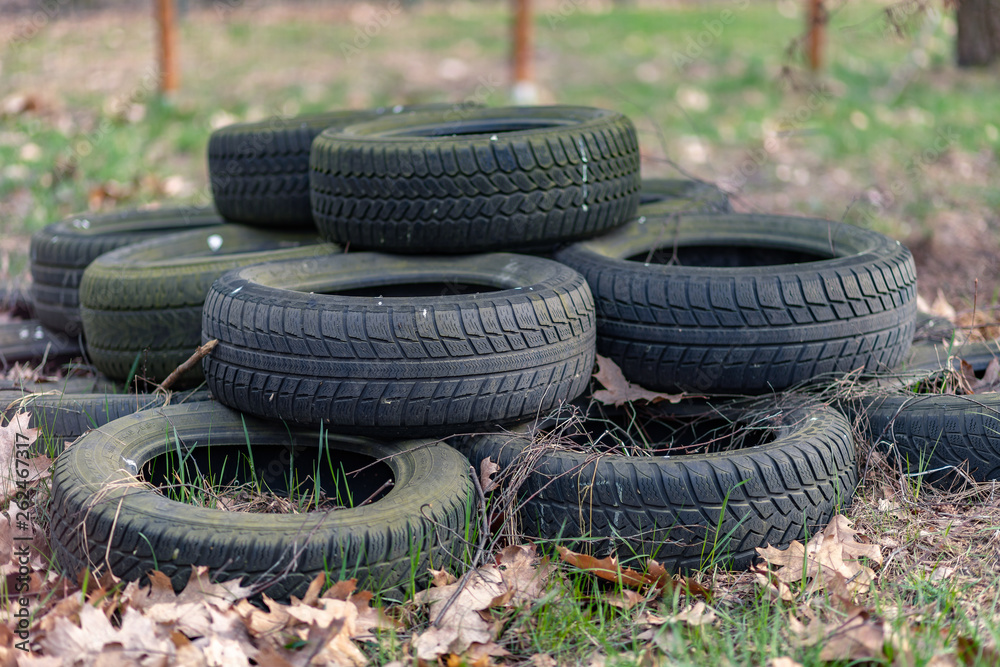 Old used car tires left, dumped in the forest, environmental concept