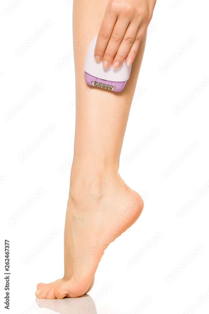 woman remove her leg hair with electric epilator on white background woman remove her leg hair with electric epilator on white background