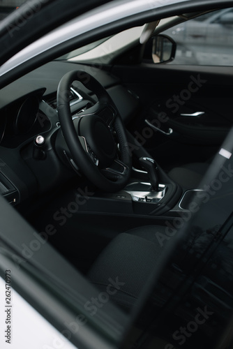 selective focus of black steering wheel near gear shift handle in luxury car © LIGHTFIELD STUDIOS