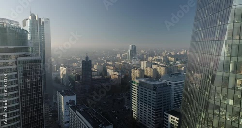 Drone footage of backwards movement in between glass office buildings in Warsaw city center.