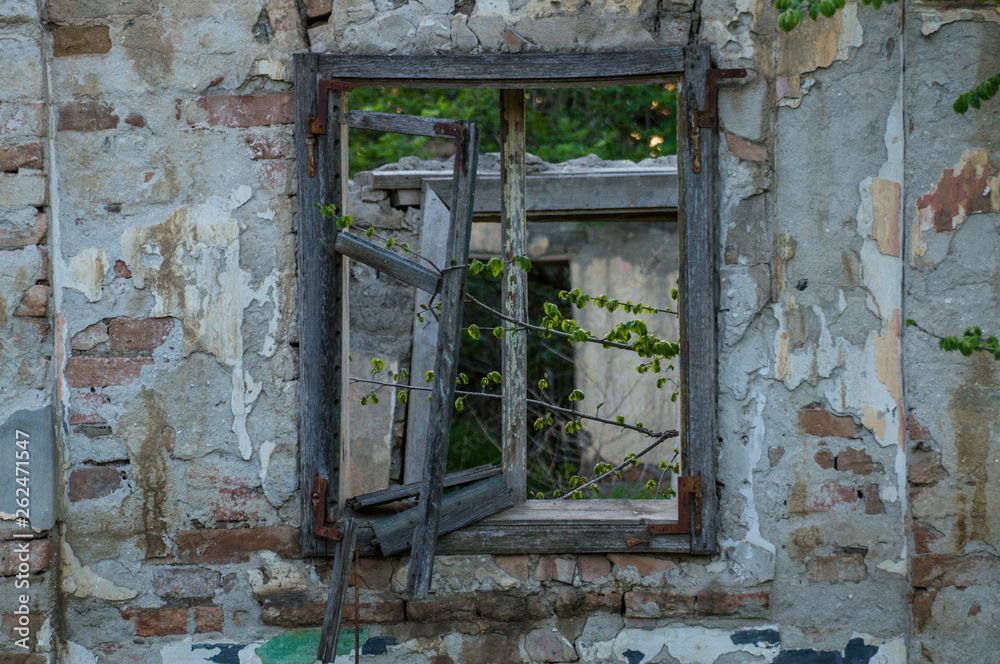 Old house in a village with a broken wooden window.