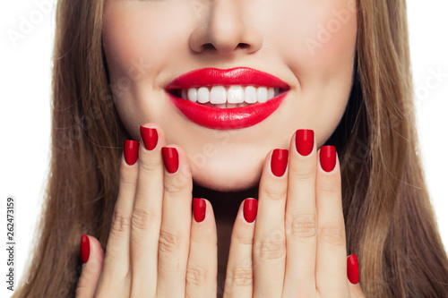 Woman hands with red manicured nails and red lips makeup
