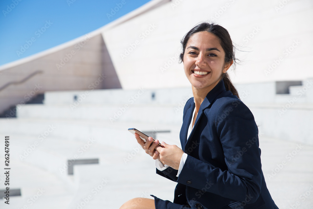Smiling joyful businesswoman using smartphone outdoors Smiling joyful businesswoman using smartphone outdoors