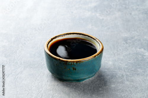 Behang soy sauce in a plate on a gray stone background