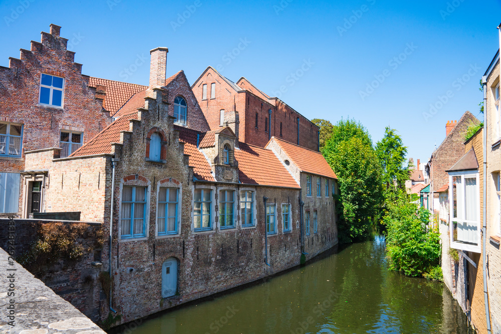 houses with orange roof tiles along canal in historic town Bruges, Brugge, Belgium. Speelmansrei