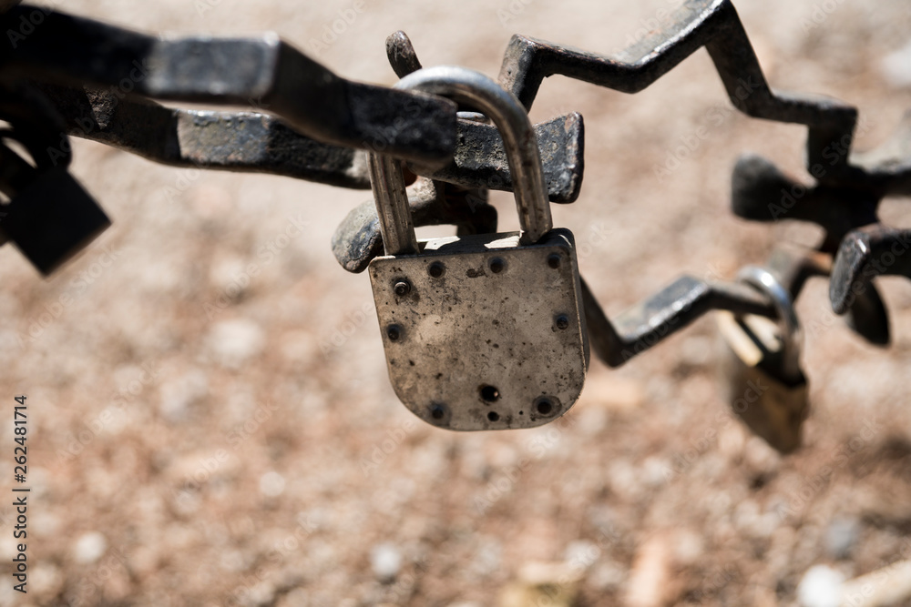 rusty chain and padlocks hanging on bridge in Brugge, Bruges, Belgium rusty chain and padlocks hanging on bridge in Brugge, Bruges, Belgium