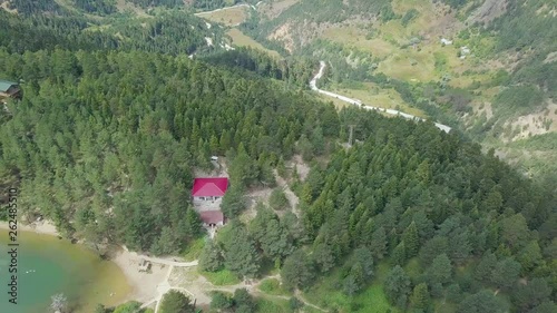 aerial drone shot over a lake surrounded by red roofed houses and forest, in Turkey photo