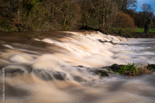 The weir at Tipton St John on the River Otter at full force with all the rain following Storm Gareth, long exposure to smooth out the water. photo