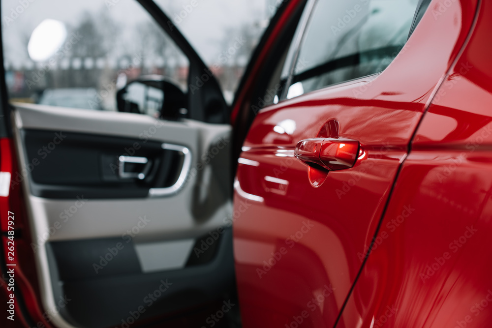 selective focus of shiny car door of red automobile