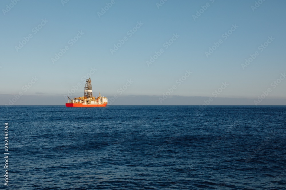 offshore oil and gas drillship, blue ocean background
