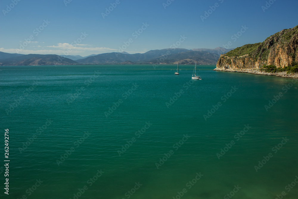 Mediterranean sea bay surrounded by mountain in south Greece coast line with cruise ships on calm water surface, summer vacation concept for tourist agency with empty copy space for text