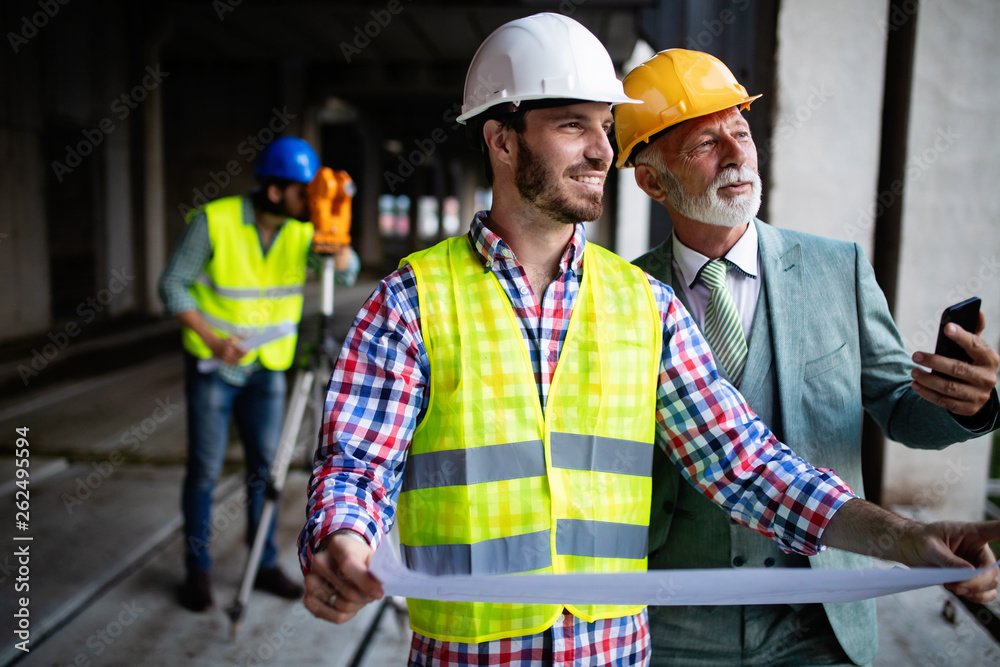 Team of architects and engineer in group on construciton site check documents and business workflow Team of architects and engineer in group on construciton site check documents and business workflow