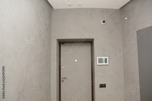 Modern house entrance metal door interior with smart house alarm systems.