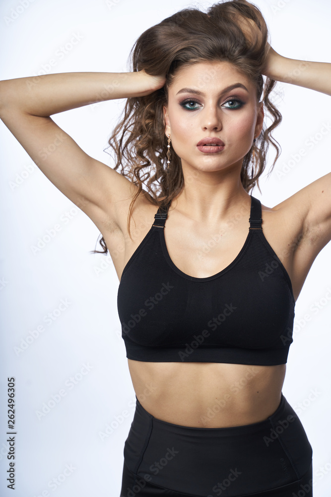 Beautiful girl in swimsuit posing against grey white background Beautiful girl in swimsuit posing against grey white background