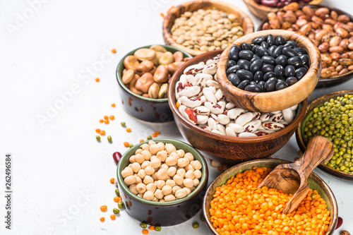 Legumes, lentils, chikpea and beans assortment on white.