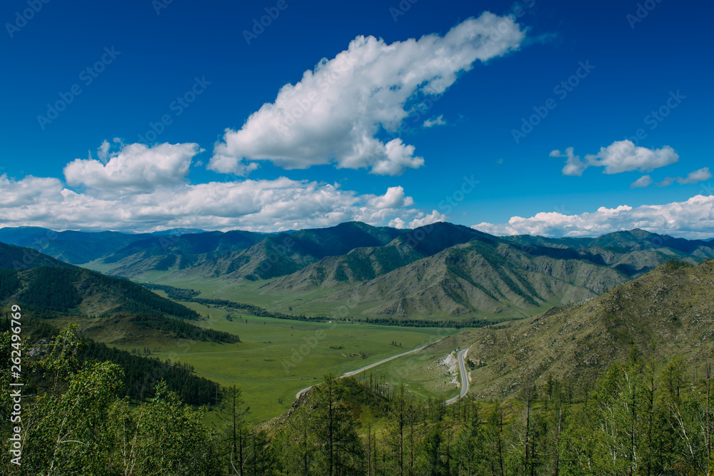 Spectacular landscape overlooking the green valley in the mountains. Journey in the mountains of Altai. Sunny summer day.