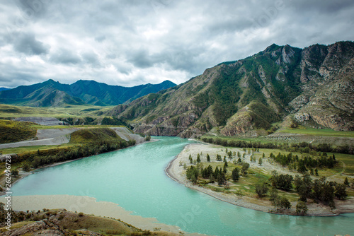 Picturesque view on the confluence of two mountain rivers. Katun river and Chuya river against of Altai mountains, Russia. Mountain landscape on a cloudy summer day.