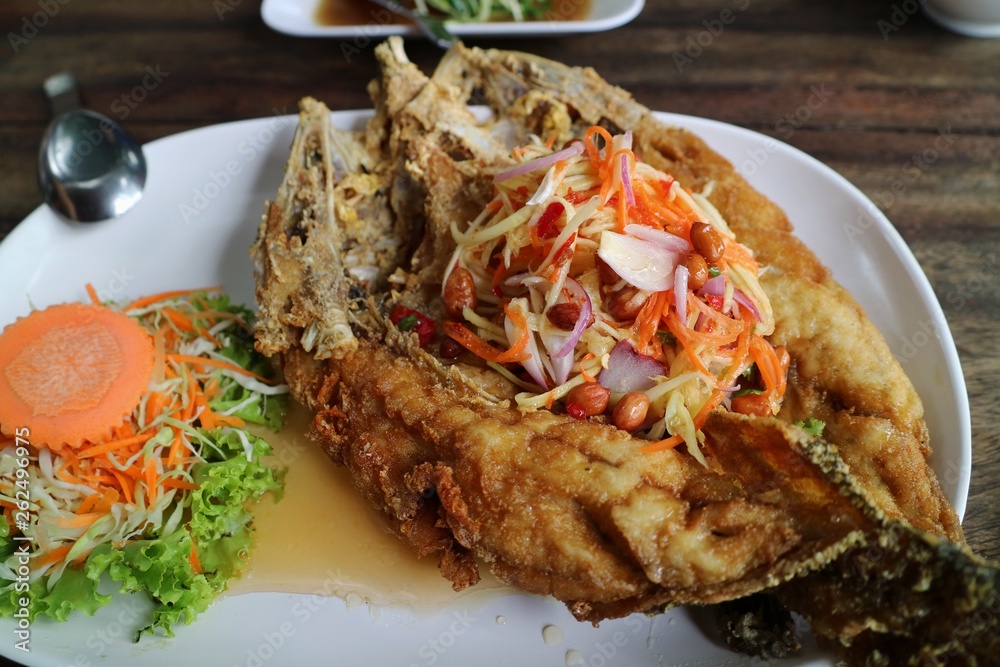 Fired fish with fish-sauce, Snapper topped with sauce, with spicy seafood sauce and vegetable. Thai food. Fired fish with fish-sauce, Snapper topped with sauce, with spicy seafood sauce and vegetable. Thai food.