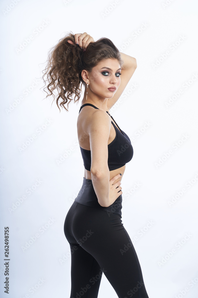 Obraz premium Beautiful girl in swimsuit posing against grey white background