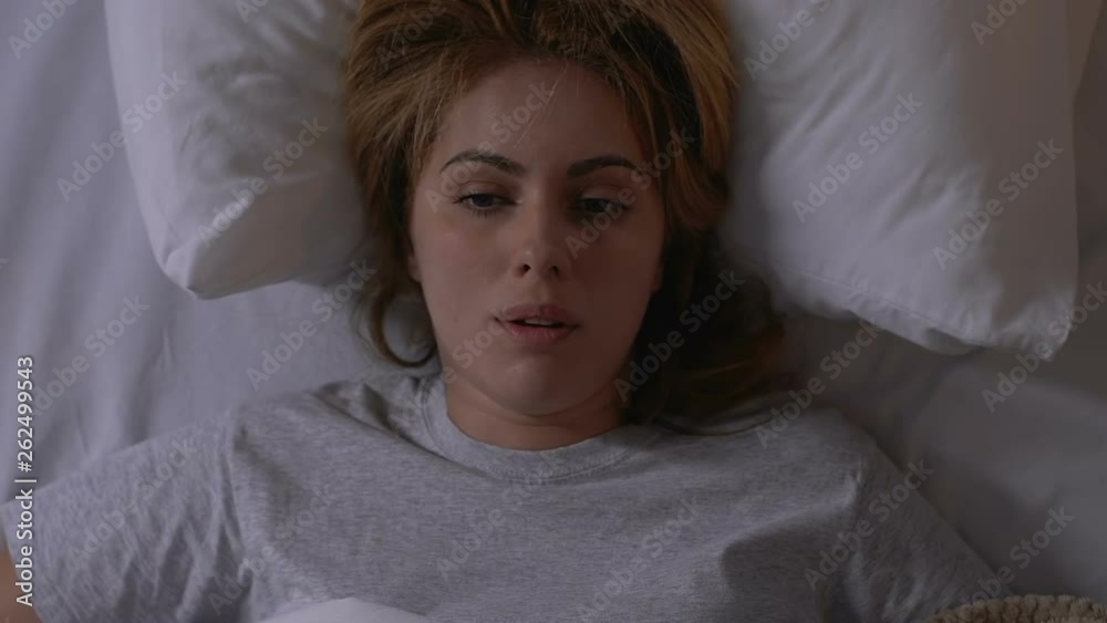 Young woman taking off blanket, hardly waking up in morning, sleep schedule Young woman taking off blanket, hardly waking up in morning, sleep schedule