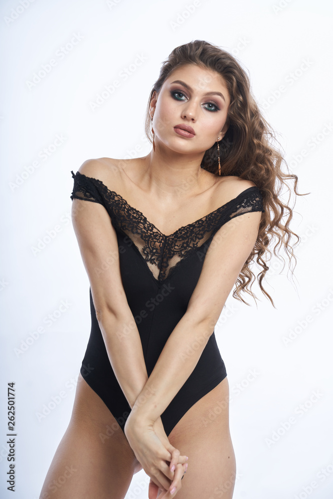 Beautiful girl in swimsuit posing against grey white background Beautiful girl in swimsuit posing against grey white background