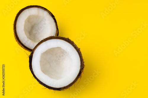 Coconut on yellow colored background, flat lay, top view