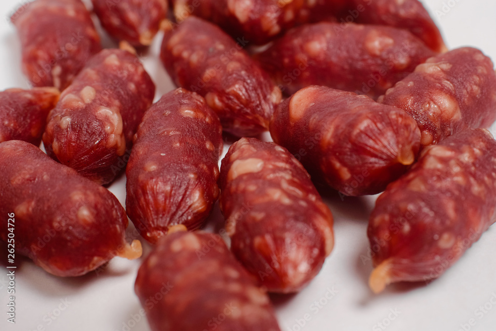Snack to beer. Small sausages to frothy drink. Background of sausages on a light background close up. Snack to beer. Small sausages to frothy drink. Background of sausages on a light background close up.