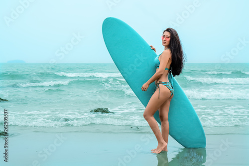 pretty Asian model in bikini playing surfboard on beach © Mongkolchon